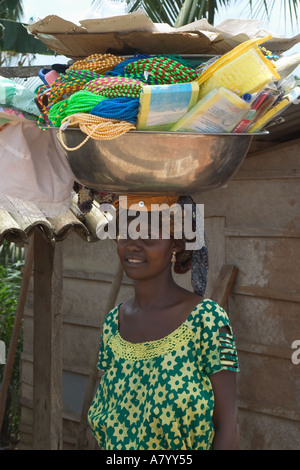 Piuttosto West African street trader vendono merci dalla coppa portati sulla sua testa, Ghana Africa occidentale Foto Stock