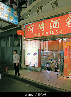 Cina Shanghai Hawker sorge al di fuori del piccolo ristorante a Shanghai per incoraggiare le persone ad entrare e a mangiare Foto Stock