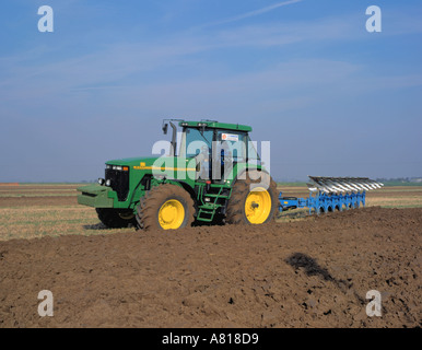 John Deere trattore 8400 con otto solco aratro reversibile (stato dell'arte il trattore di design tradizionale). Foto Stock