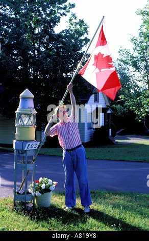 Canada, Moncton, francofono capitale del New Brunswick, anglofono sollevando la bandiera canadese Foto Stock