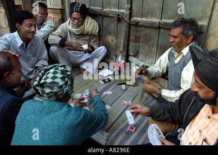 Un gruppo di Indiani gli uomini giocano a carte sulla strada a Delhi in India Foto Stock