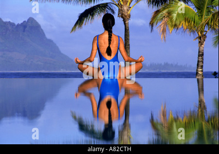 La donna in posizione di yoga sul bordo della piscina a Hanalei Bay sull isola di Kauai nelle Hawaii Foto Stock