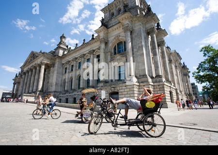 Una guida turistica in attesa sul suo rickshaw al di fuori del Reichstag a Berlino, Germania Foto Stock