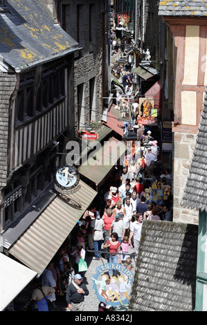 Turisti e negozi di souvenir lungo la Grande Rue di Mont St Michel Foto Stock