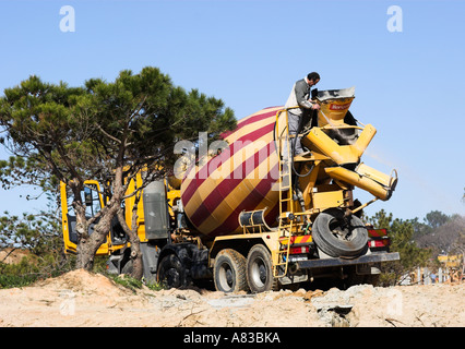 Calcestruzzo carrello essendo lavato giù dopo la consegna di un pieno carico di calcestruzzo preconfezionato. Foto Stock