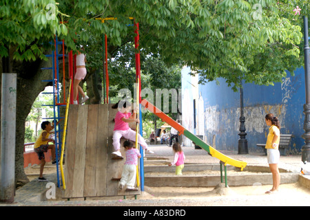 Bambini che giocano su aslide e oscilla in Caminito, La Boca, Buenos Aires Foto Stock