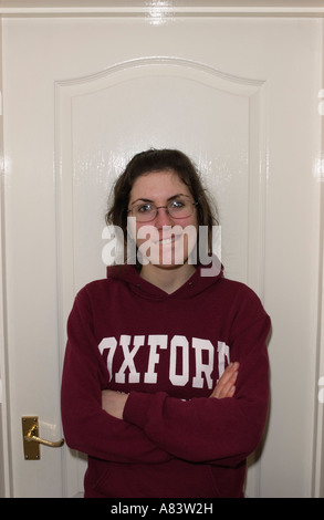 Ritratto di ragazza con gli occhiali e Oxford University felpa con porta bianca in background Foto Stock