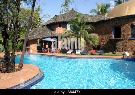 Palm tree frame che la piscina a forma libera con gli spettacolari designer Nilaya Hermitage boutique hotel in Goa in India Foto Stock