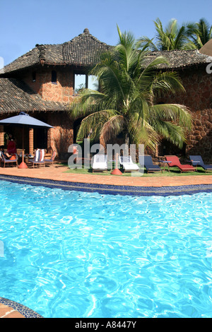 Palm tree frame che la piscina a forma libera con gli spettacolari designer Nilaya Hermitage boutique hotel in Goa in India Foto Stock