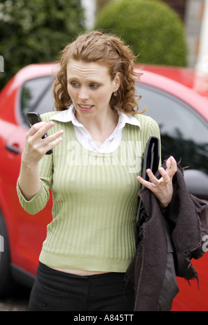 La ragazza ha sottolineato a ricevere il messaggio sul telefono cellulare Foto Stock