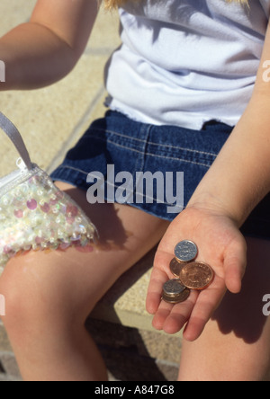 Ragazza con un piccolo cambiamento nella mano Foto Stock