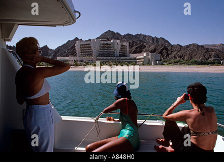 Oman. Il Muscat. Crociera turistica al largo nella regione della capitale. Al Bustan Palace hotel e spiaggia incontaminata in background. Foto Stock