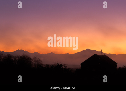 Fienile stagliano sunrise Cascade Mountains in background Spencer Isola Everett Snohomish estuario del fiume Washington Foto Stock