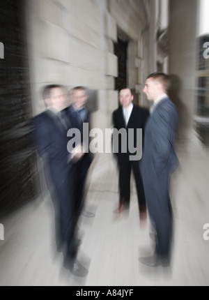 Quattro uomini d'affari 4 che pongono in esecuzione in Leeds Millennium Square per un servizio fotografico commerciale Foto Stock