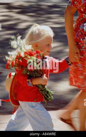 Madre e figlia correre lungo il marciapiede della città Foto Stock