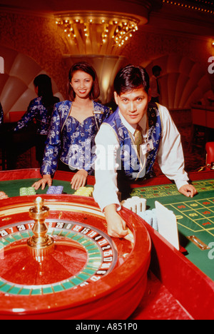 Filippine. Manila. Maschio e femmina Croupiers nel casinò di ruota della Roulette. Foto Stock