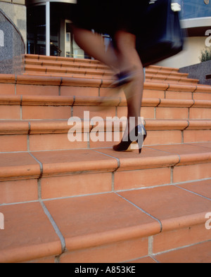 Close-up di imprenditrice per le gambe come corre fasi di costruzione della città. Foto Stock