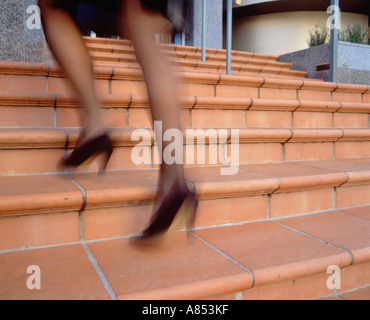 Close-up di imprenditrice per le gambe come corre fasi di costruzione della città. Foto Stock