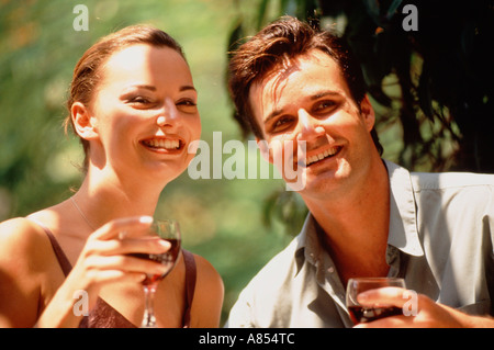 Outdoor ritratto di felice giovane uomo e donna di bere vino rosso. Foto Stock