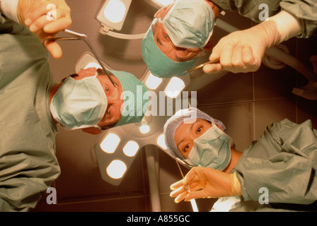 Piscina di close-up di sala operatoria team chirurgico del paziente dal punto di vista del sovraccarico con illuminazione spot. Foto Stock