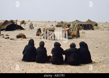 Il Sudan. Vista posteriore della fila di Beduino seduto donne vestite di nero tradizionale hijabs. Foto Stock