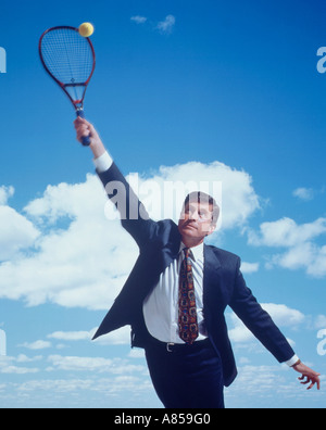 Il concetto di business. Executive maschio indossare tuta e giocare a tennis. Foto Stock