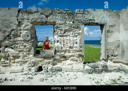 Woman in Red pareo nella costruzione di rovine grande Issac Isola Bahamas Foto Stock