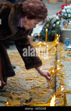 Serbo-bosniaco donna accende una candela in un memoriale di Slobodan Milosevic a Banja Luka centro città la Repubblica Srpska in Bosnia Herzego Foto Stock