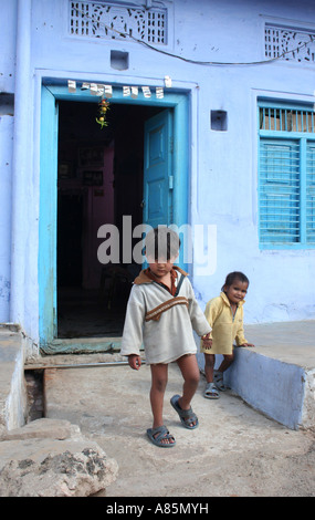 Due giovani ragazzi giocare alla porta di una casa blu in Pushkar, Rajasthan, India. Foto Stock