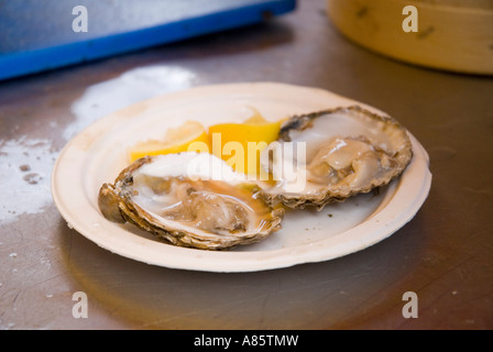 Ostriche fresche servita su una piastra in una fase di stallo nel mercato di Borough Londra England Regno Unito. Foto Stock