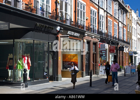 People Shopping e passeggiate lungo la zona pedonale ricurva con vetrine e negozio di curva fronti, South Molton Street, Off Oxford Street, Londra Foto Stock