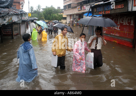 Indian School i bambini sulla strada allagata nel record monsone di pioggia pesante giorno a Bombay città di Mumbai India Foto Stock