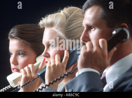 Tre telemarketers parlando sui telefoni Foto Stock