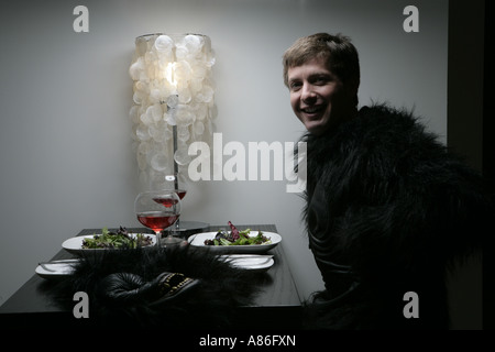 Uomo in gorilla cliente seduto da solo sul tavolo Foto Stock