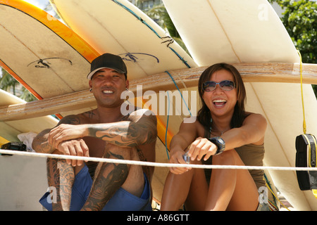 Due persone sedute sotto le tavole da surf Foto Stock