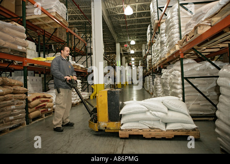 Vista di un lavoratore movimentazione merci su un pallet. Foto Stock