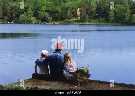 Papà e bambini sul lago pesca picnic in Svezia durante il periodo estivo Foto Stock