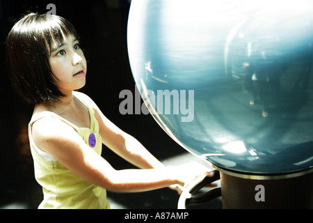 Ragazza osservando globe Foto Stock