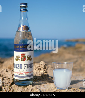 Bottiglia e bicchiere di Ouzo sulla spiaggia, Grecia Foto Stock