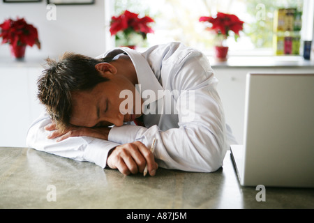 Giovane uomo sonnecchiare sul lavoro Foto Stock