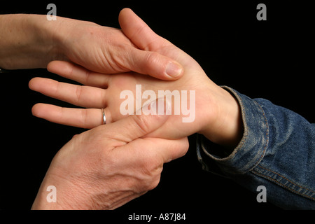 Close up di un terapeuta dando un "posto di lavoro" massaggio mano per aiutare ad alleviare lo stress sul lavoro. Foto Stock