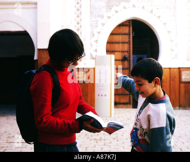 Giovani femmine turisti asiatici con libro guida chiedendo fordirections dal giovane ragazzo locale,Fez,Marocco Foto Stock