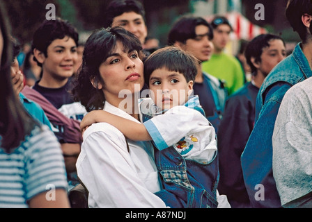 I giovani cileni azienda madre figlio maschio durante la visione di un concerto all'aperto a Valparaíso Cile Foto Stock