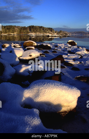 Coperta di neve rocce lungo la riva di Hjalteby, Tjorn (isola), bohuslan, la costa occidentale della Svezia Foto Stock