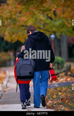 Madre figlio a piedi a casa da scuola Foto Stock