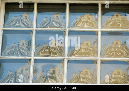 Riflessi distorti di edifici storici nei vetri delle vecchie finestre a Danzica, Pomorskie, Polonia. Foto Stock