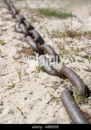 Mezzo sepolto catena di ferro sulla sabbia Foto Stock