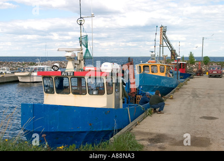 Due pescatori di parlare oltre il blu dipinto di pescherecci per la pesca a strascico al porto di Oulunsalo Finlandia Foto Stock