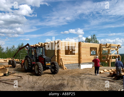 Log Cabin in costruzione e la gente parlare insieme oltre la cabina , Finlandia Foto Stock