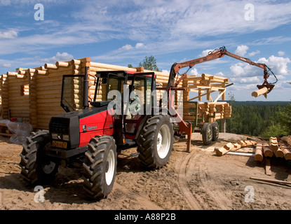 Valmet trattore sollevando un nuovo esitano di fronte al log cabin parete , Finlandia Foto Stock